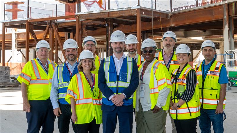 JMP staff in construction jackets and hardhats smiling at camera