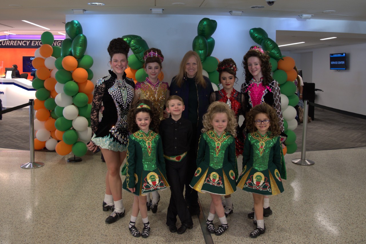 Children in traditional Irish gear smiling with Terminal 7 staff