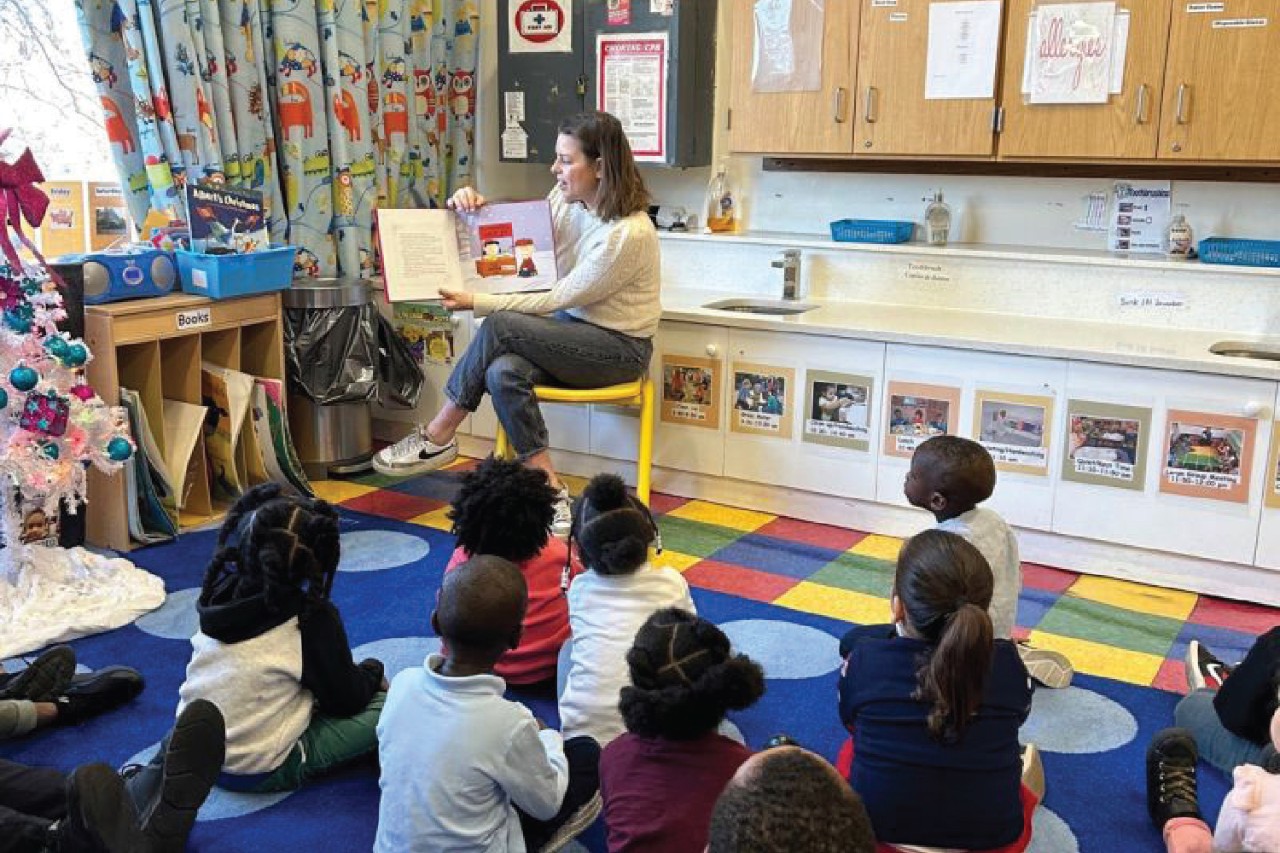 Volunteer reads to children for Homes for the Homeless