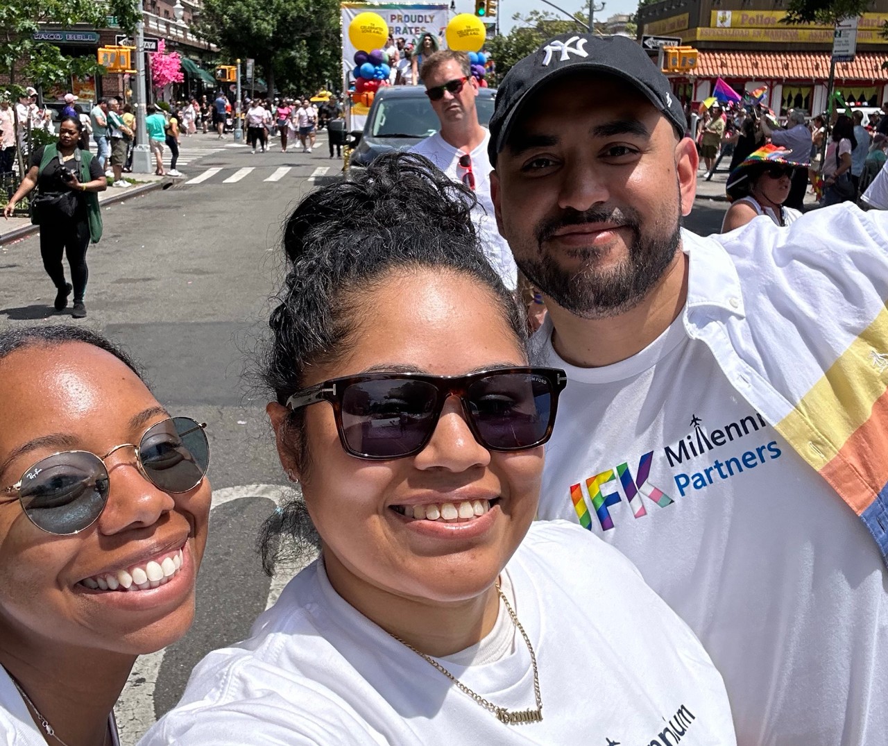 Three people smile at the camera while standing outside